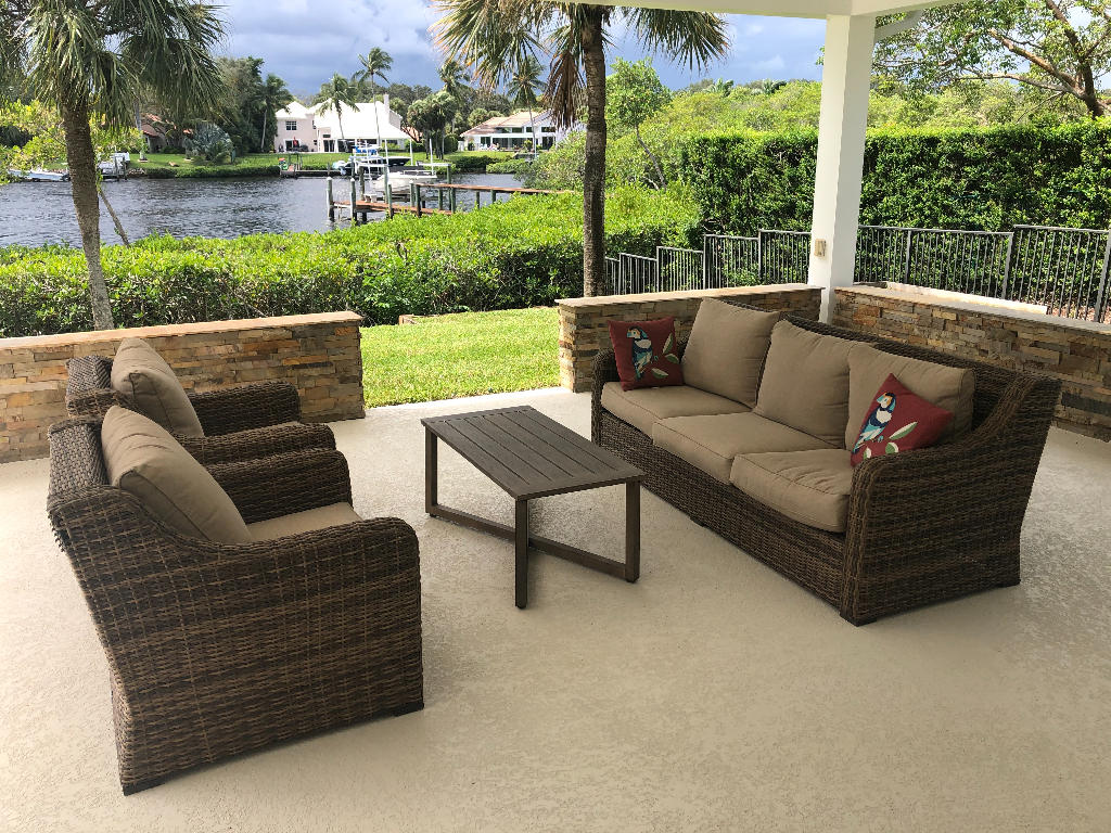 18169 Southeast Ridgeview Drive Tequesta, FL 33469 - Photo 20 of 23 a view of a patio with couches chairs and a yard
