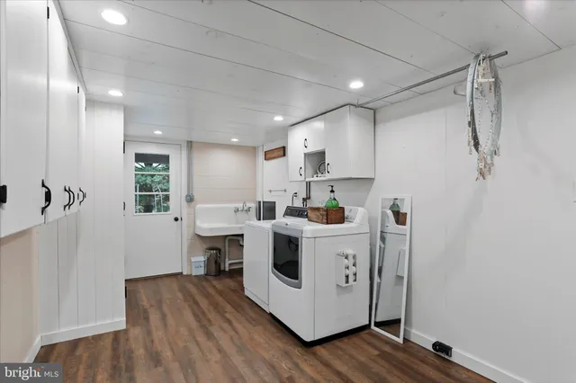 a view of kitchen with stainless steel appliances refrigerator stove microwave and wooden floor