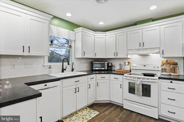 a kitchen with white cabinets and white appliances
