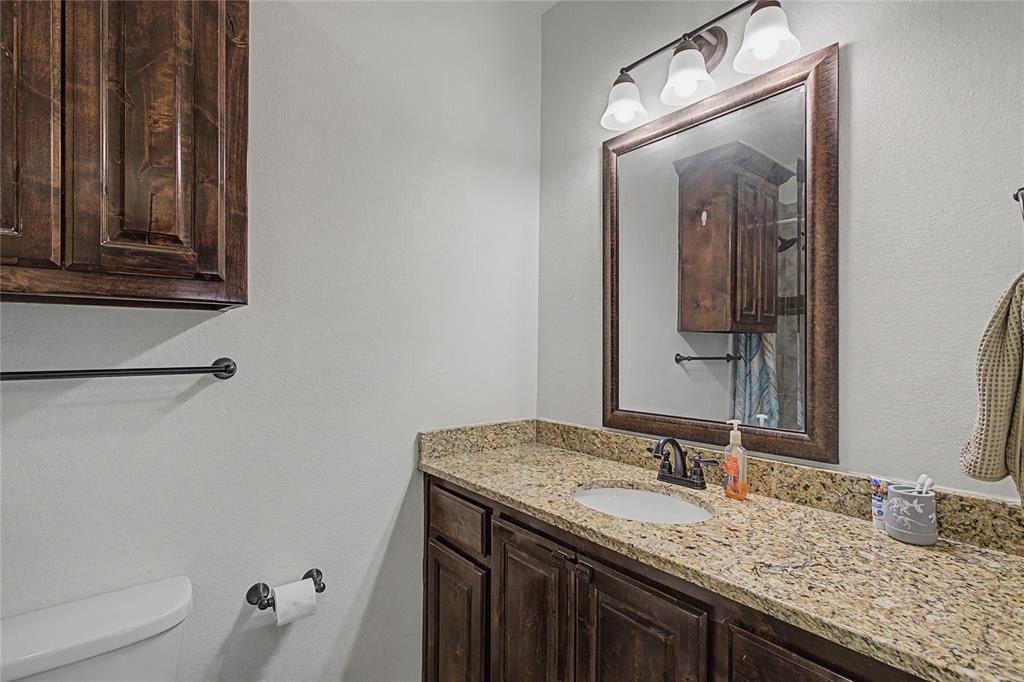 208 Lovers Path Drive Springtown, TX 76082 - Photo 15 of 35 a bathroom with a granite countertop sink and a mirror