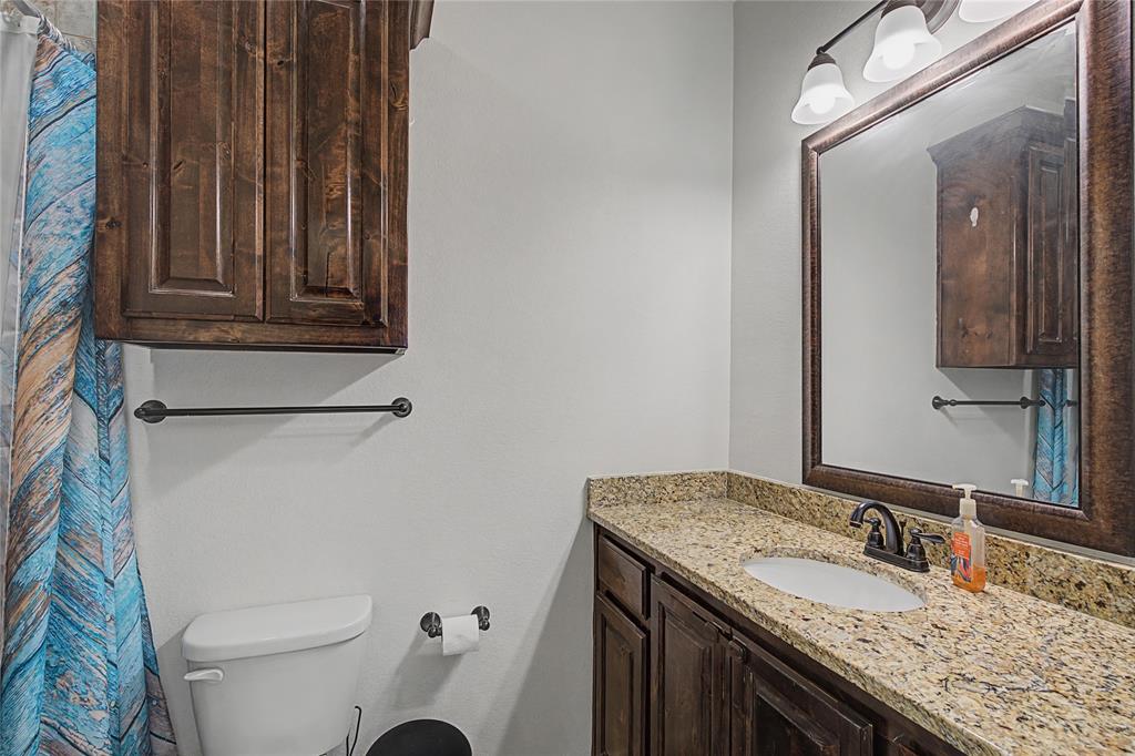 208 Lovers Path Drive Springtown, TX 76082 - Photo 16 of 35 a bathroom with a granite countertop sink a toilet and a mirror