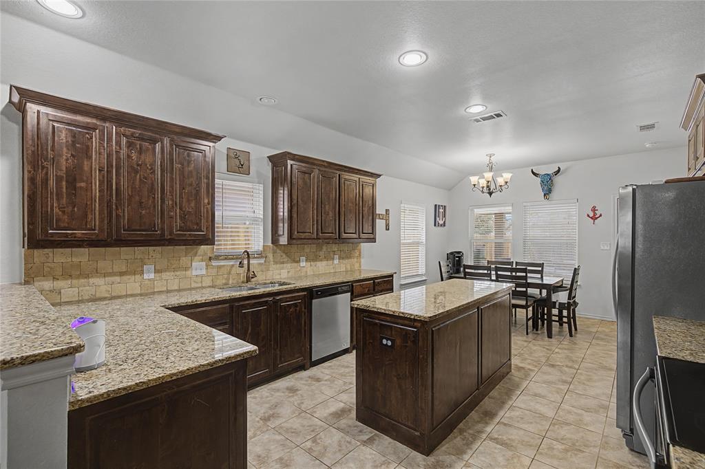 208 Lovers Path Drive Springtown, TX 76082 - Photo 3 of 35 a kitchen with granite countertop a sink counter and chairs