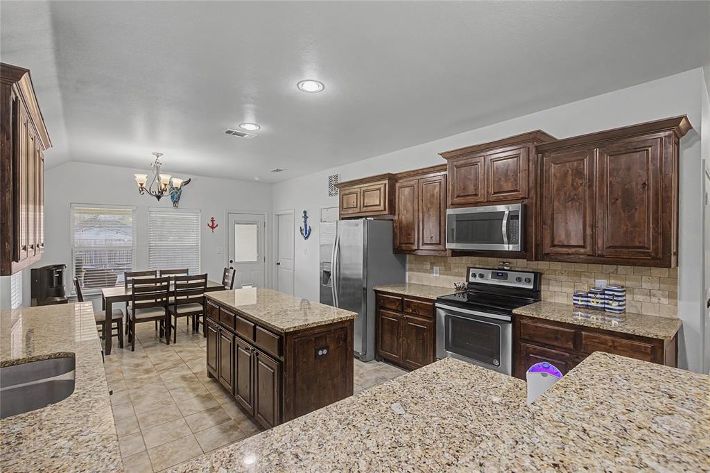 208 Lovers Path Drive Springtown, TX 76082 - Photo 9 of 35 a kitchen with granite countertop a sink stove and refrigerator