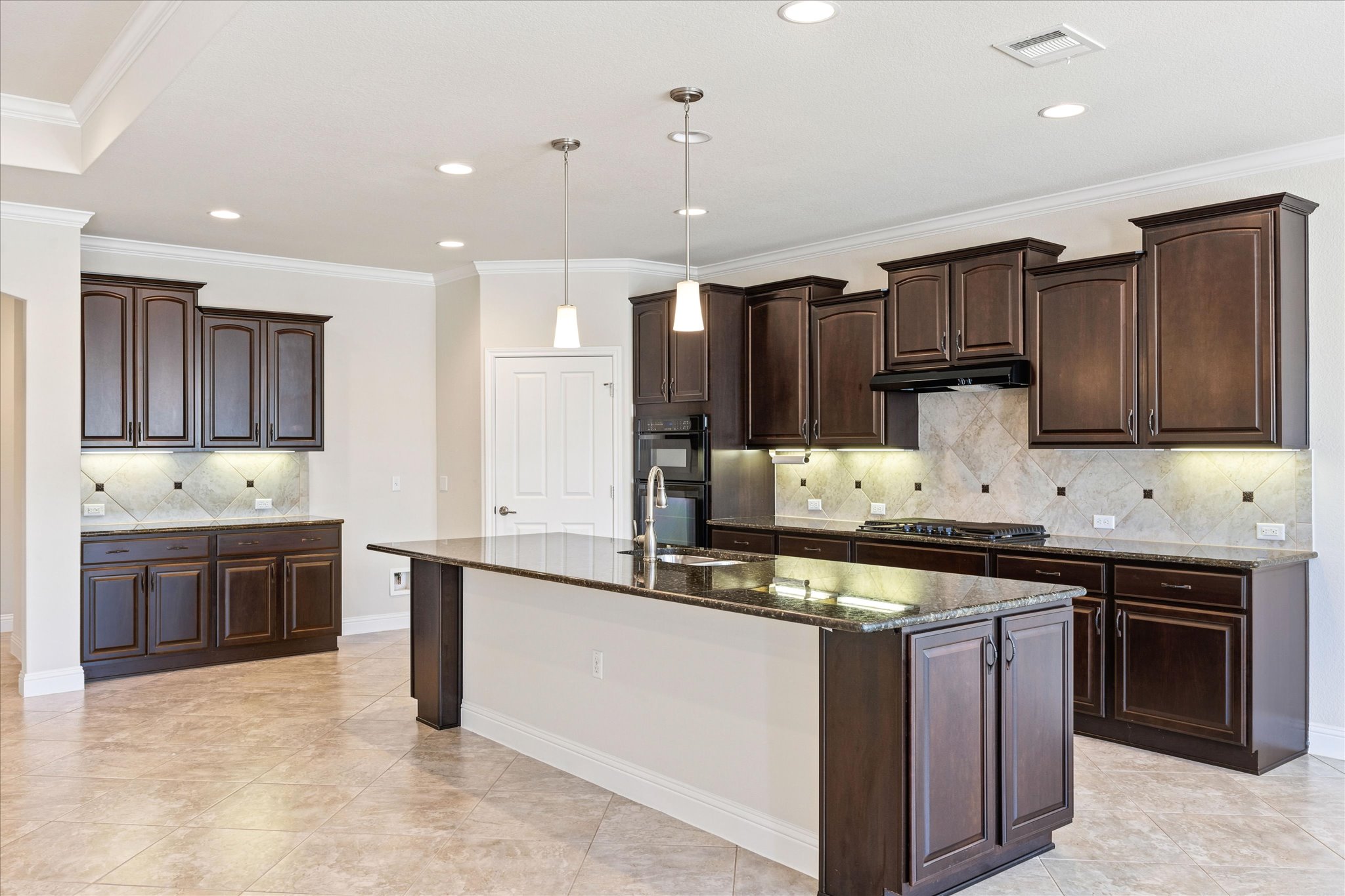 Rich dark wood cabinetry and a generous center island anchor this expansive kitchen.