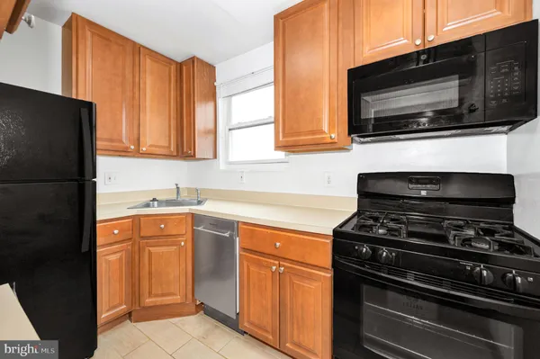 a kitchen with stainless steel appliances a stove microwave and sink