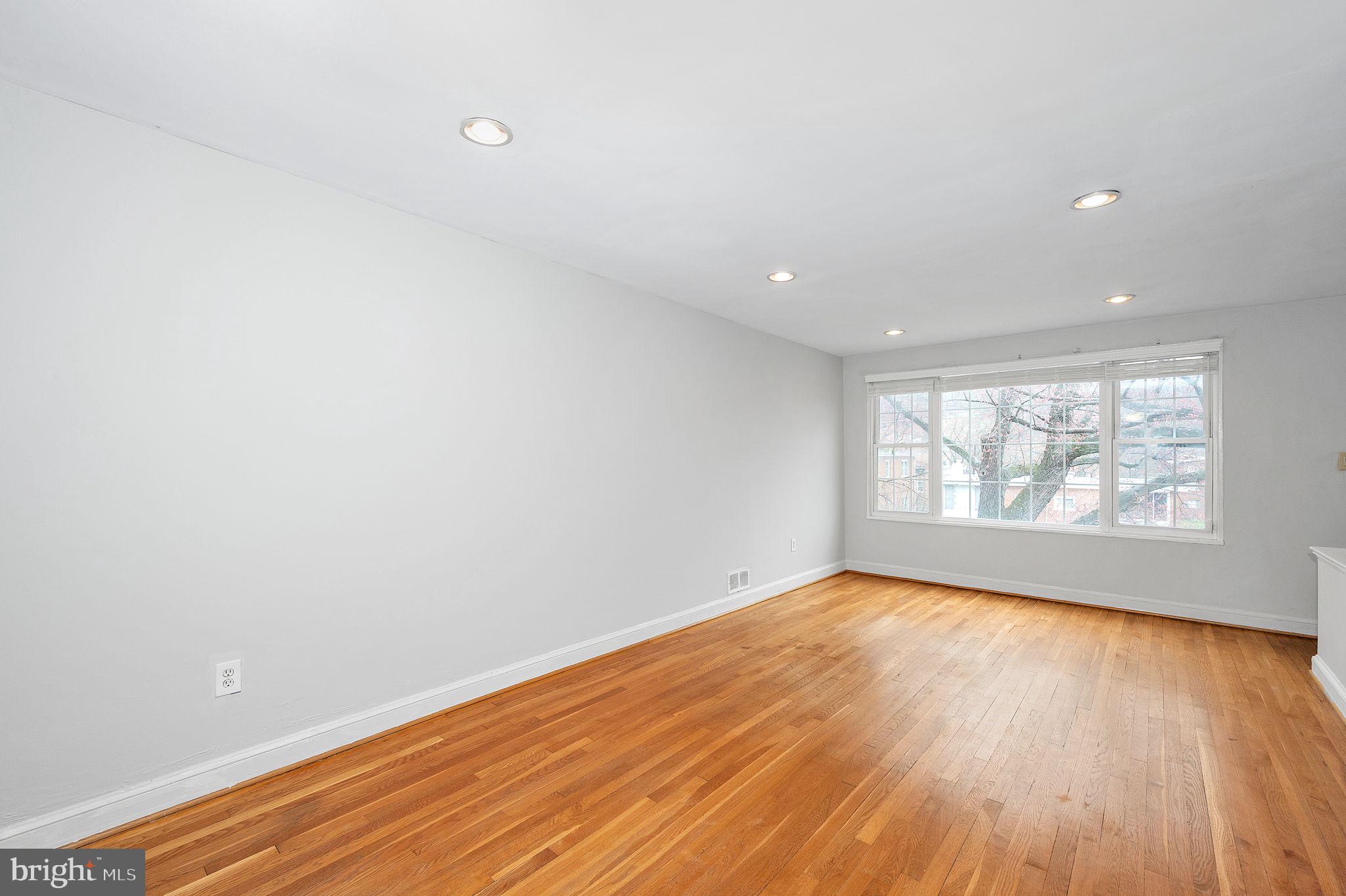 109 Webster Street Northeast Washington, DC 20011 - Photo 7 of 35 an empty room with wooden floor and windows
