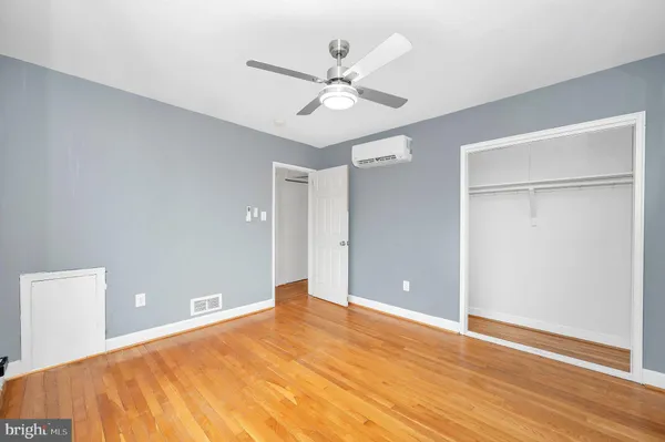 a view of a room with wooden floor and a ceiling fan