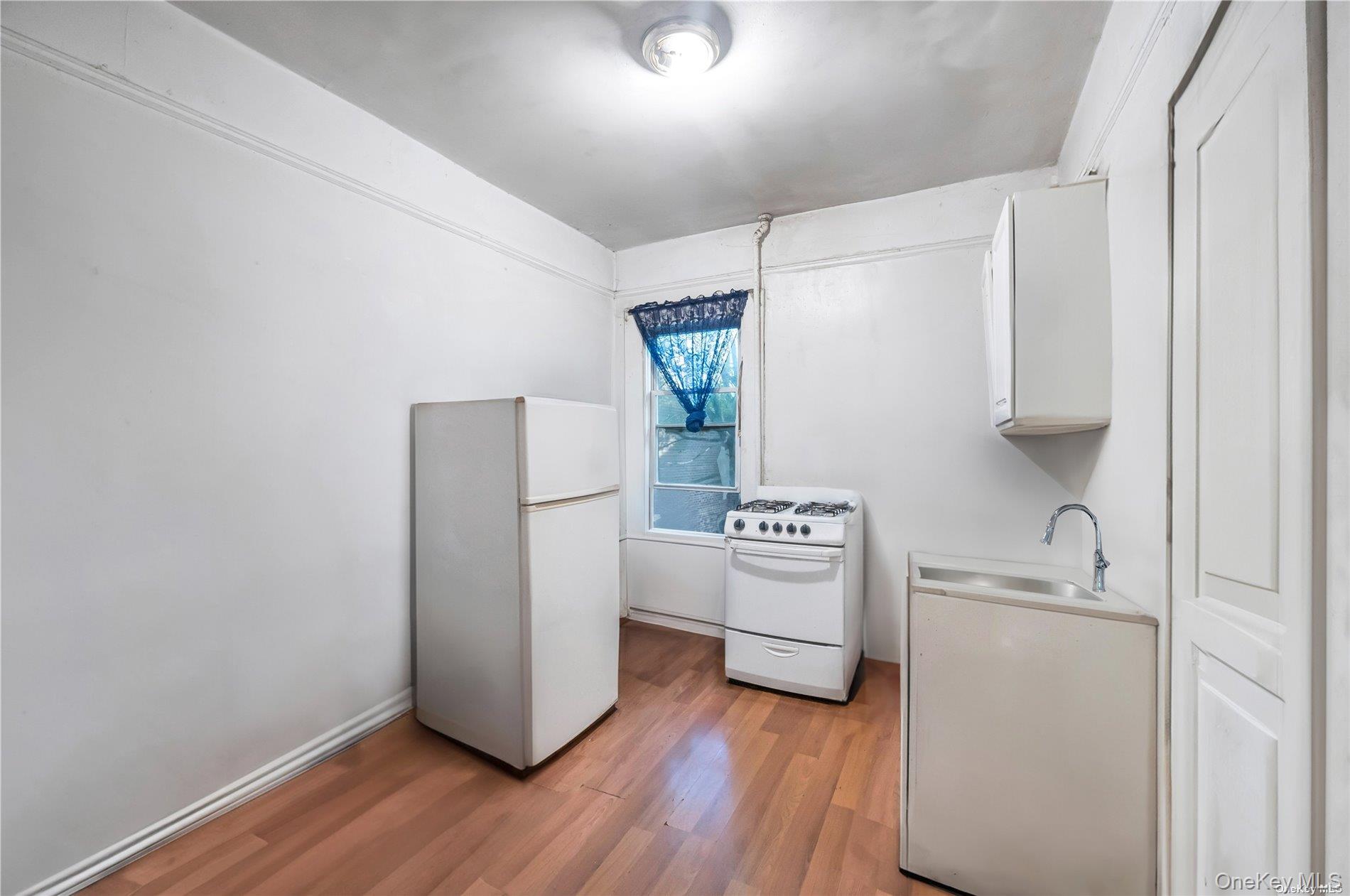 37-58 79th Street Queens, NY 11372 - Photo 13 of 28 a room with a refrigerator and a stove top oven