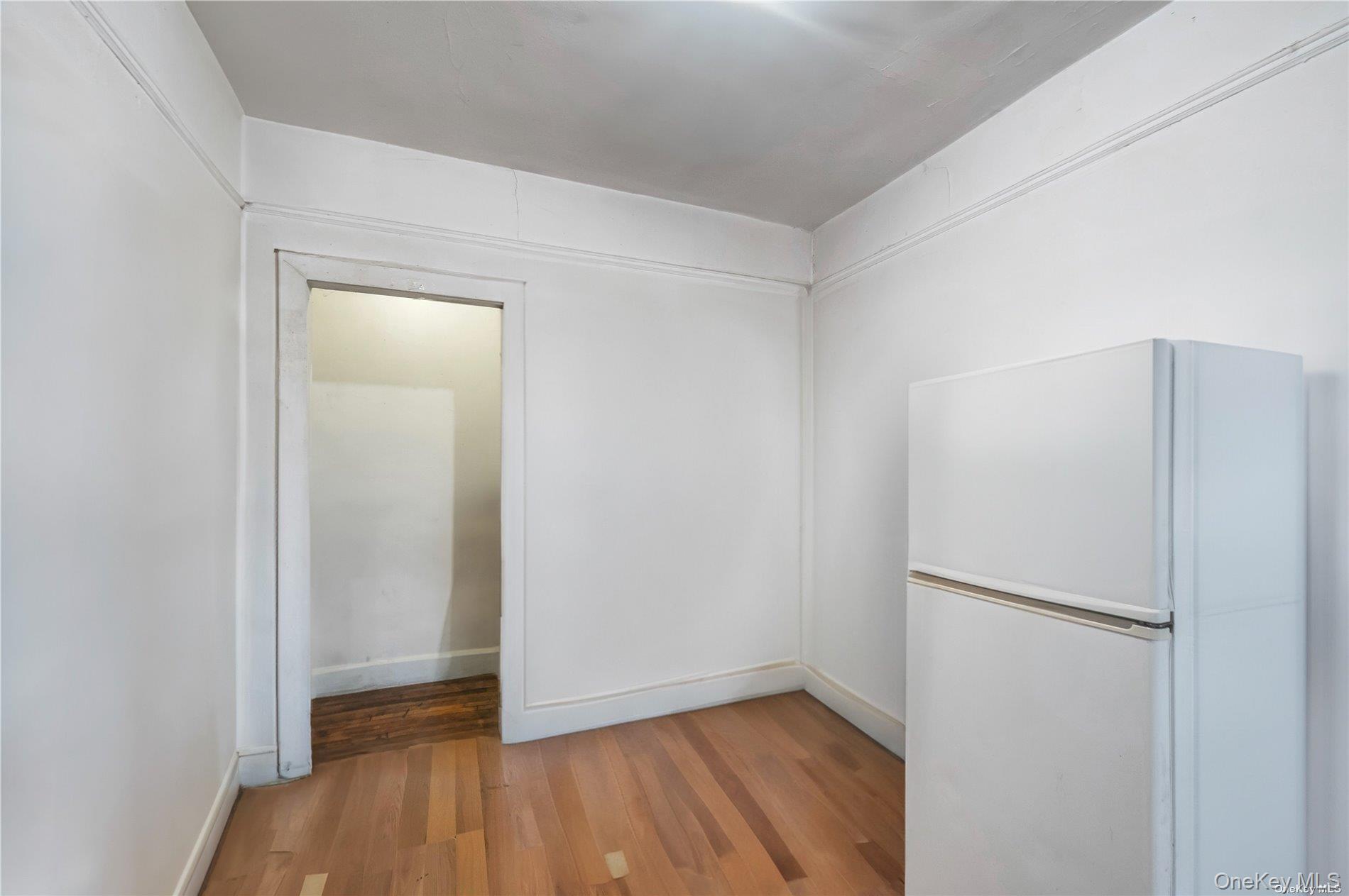 37-58 79th Street Queens, NY 11372 - Photo 15 of 28 a view of an empty room with wooden floor and a window