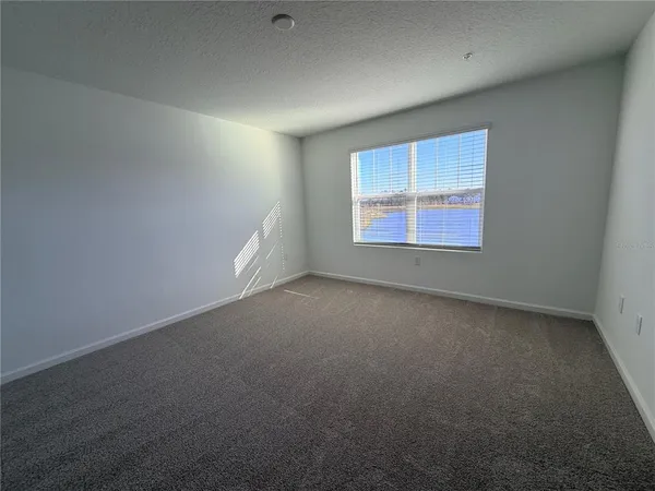 a view of a brick house with pool and lawn chairs under an umbrella