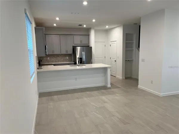 a kitchen with stainless steel appliances a refrigerator a stove a sink and white cabinets