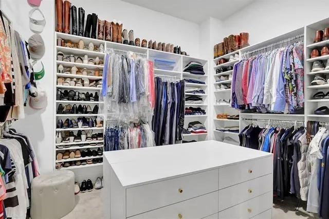 a view of walk in closet with clothes and shoes