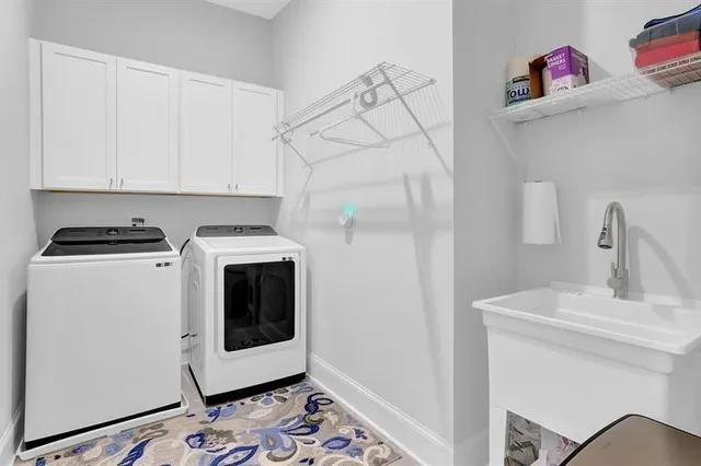a utility room with sink dryer and washer
