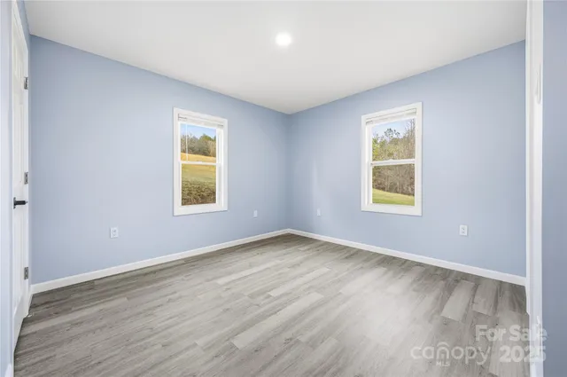 an empty room with a window and wooden floor