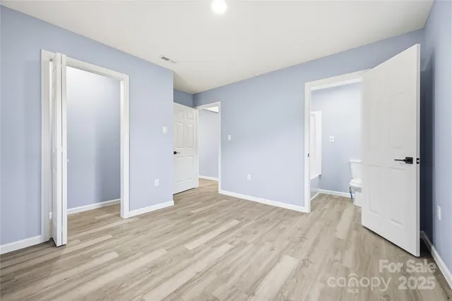 a view of a big room with wooden floor and windows