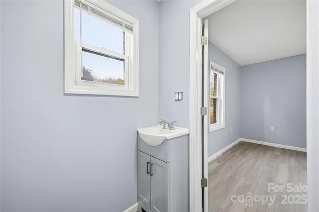 a bathroom with a sink mirror and a window