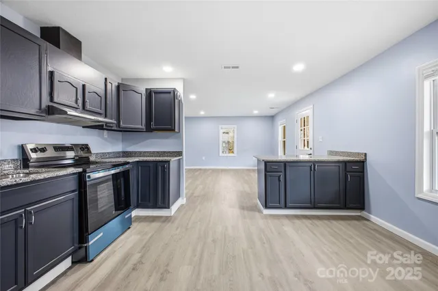 a kitchen with stainless steel appliances granite countertop a stove a sink and a refrigerator