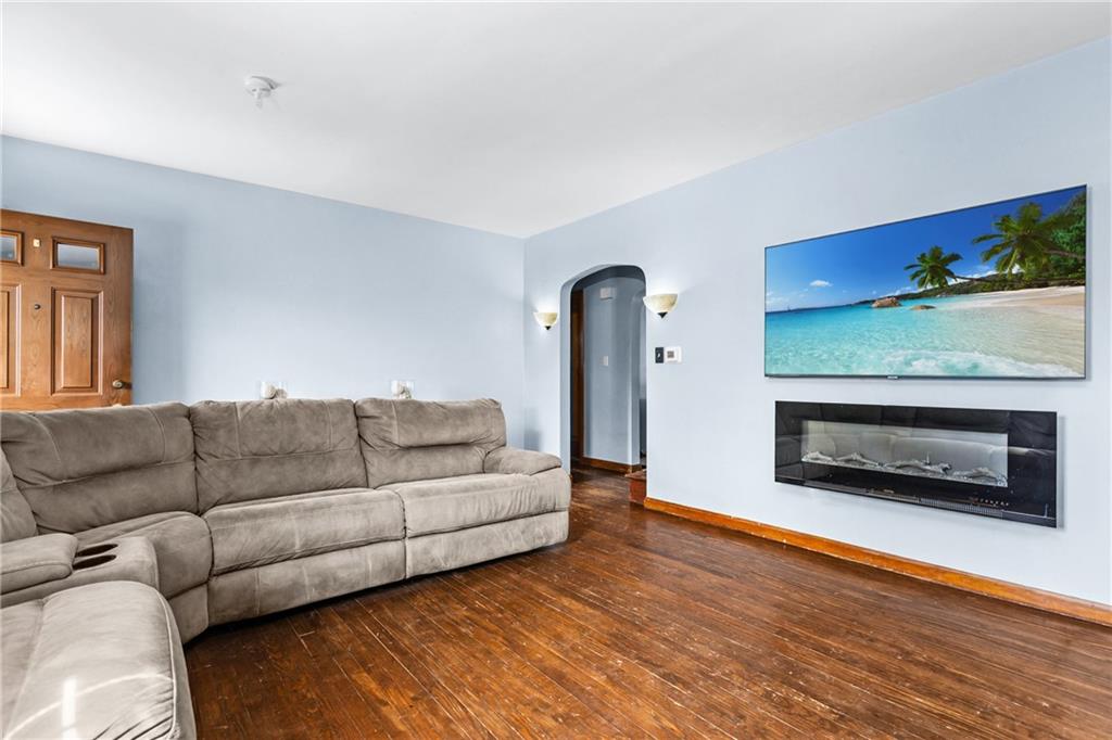 118 Oak Spring Road Canonsburg, PA 15317 - Photo 6 of 32 Spacious living room with hardwood floors and a wall-mounted electric fireplace. Perfect for entertaining or relaxing, with ample space for seating and décor.