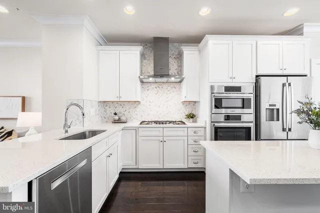 a kitchen with stainless steel appliances a sink stove refrigerator and cabinets