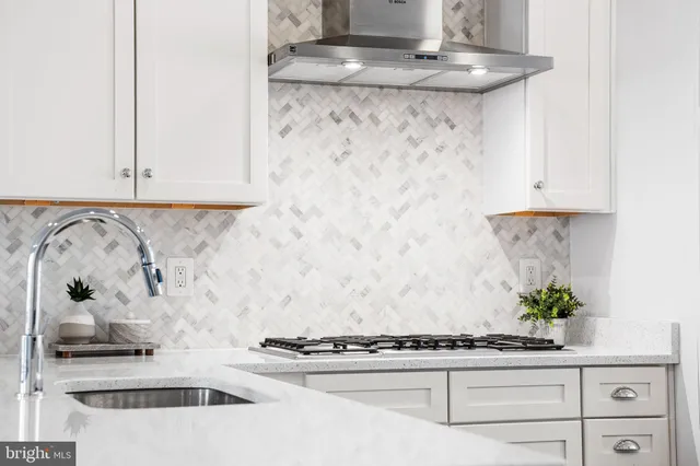 a kitchen with a stove and white cabinets