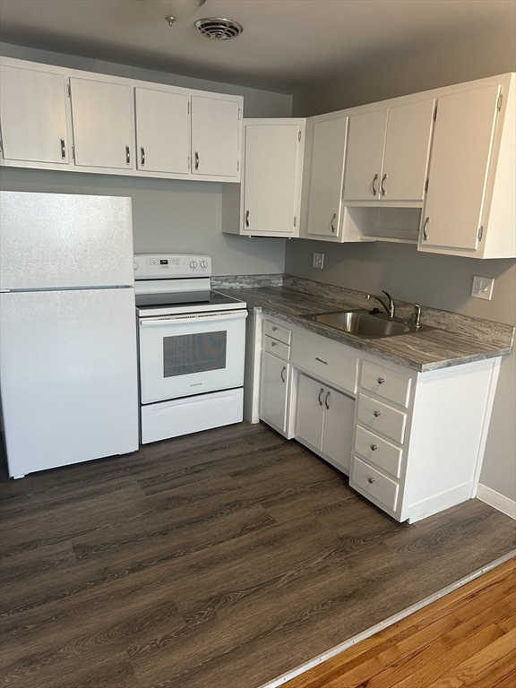 39 Carey Avenue, Unit 5 Watertown, MA 02472 - Photo 2 of 12 a kitchen with granite countertop white cabinets and white appliances
