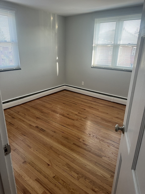 39 Carey Avenue, Unit 5 Watertown, MA 02472 - Photo 7 of 12 a view of empty room with window and wooden floor