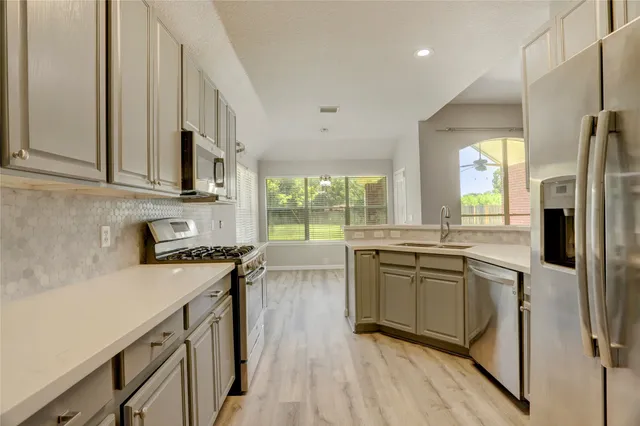 a kitchen with a sink stove and refrigerator