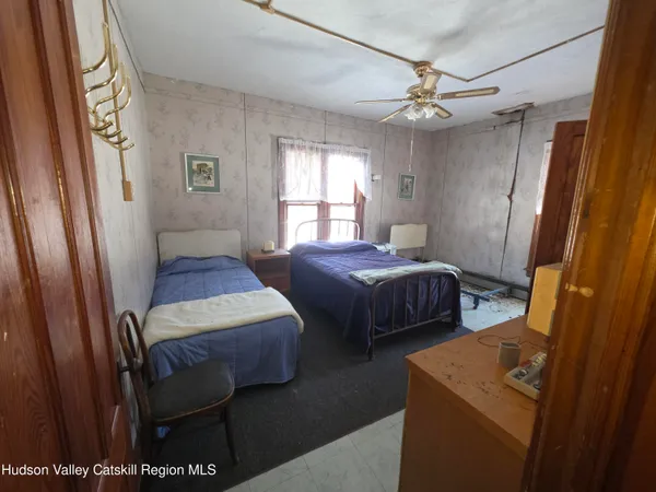 a bedroom with a bed window and mirror