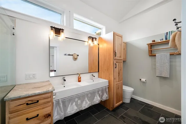 a bathroom with a double vanity sink toilet and shower