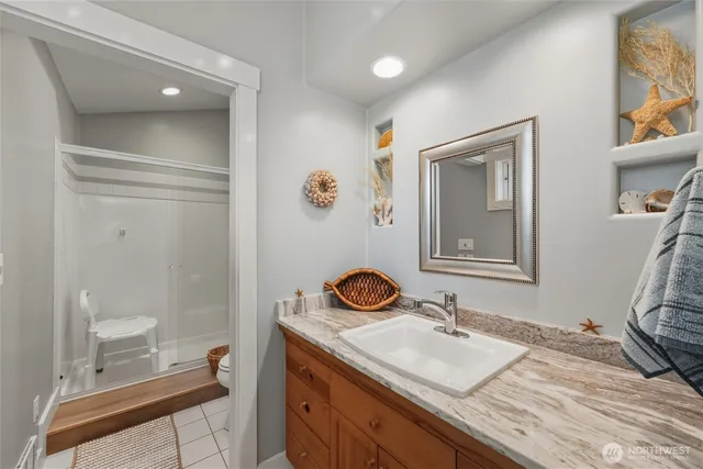 a bathroom with a granite countertop sink a toilet and a mirror