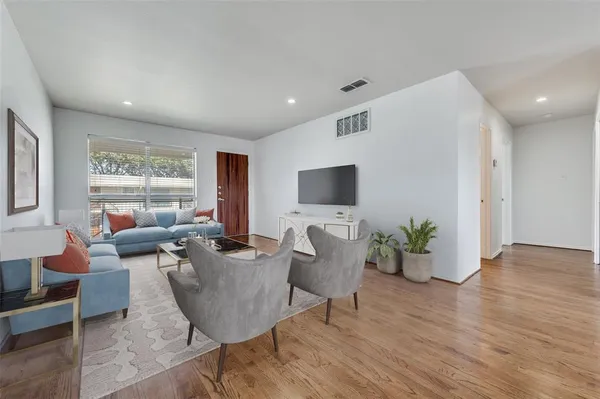 a living room with furniture wooden floor and a flat screen tv