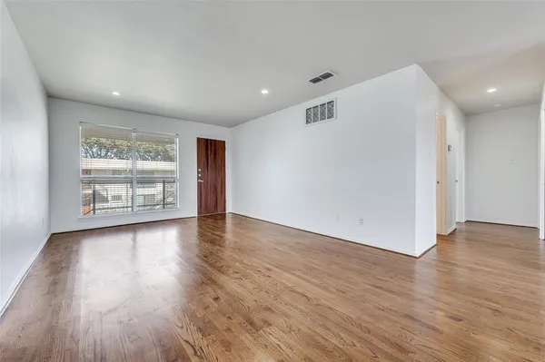 a view of a livingroom with wooden floor and window