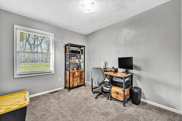 a view of a workspace with furniture and a window