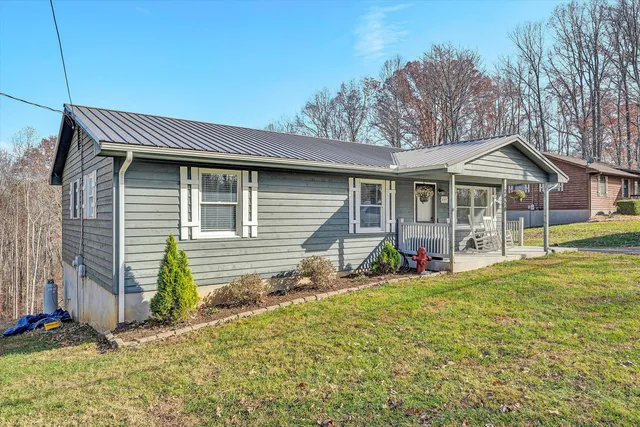 a view of a house with a yard and sitting area