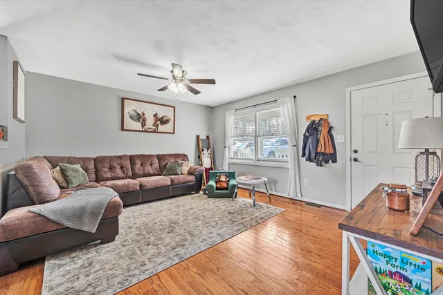 a living room with furniture and wooden floor