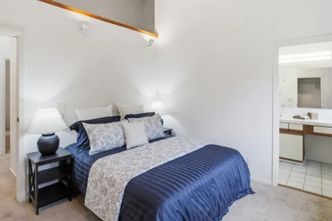 a bedroom with a bed and a view of kitchen