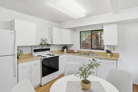 a kitchen with a dining table chairs refrigerator and cabinets