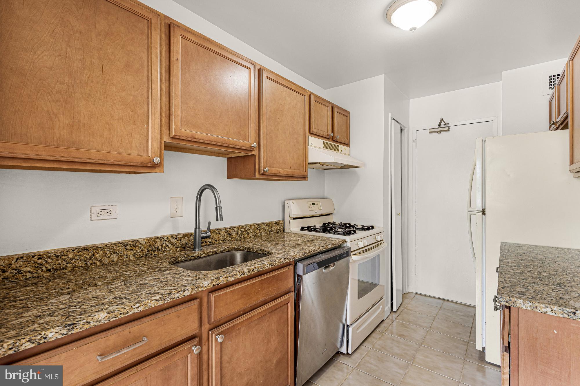 1900 Lyttonsville Road, Unit 818 Silver Spring, MD 20910 - Photo 10 of 23 a kitchen with stainless steel appliances granite countertop a sink stove and refrigerator