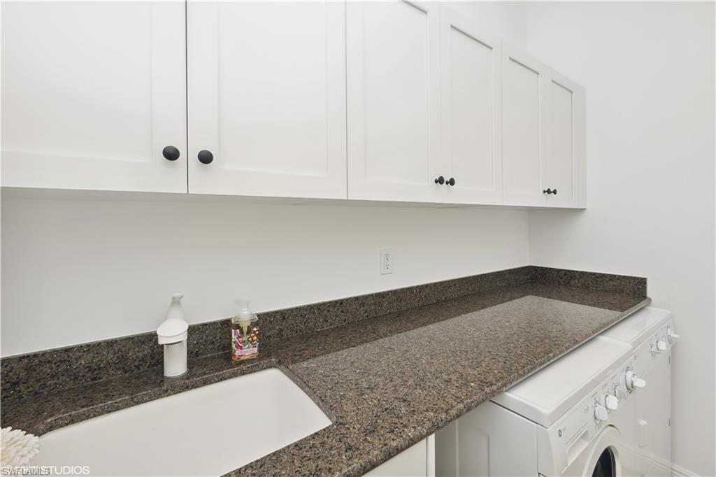 6501 Crown Colony Place, Unit 4201 Naples, FL 34108 - Photo 16 of 35 a kitchen with granite countertop white cabinets and a sink