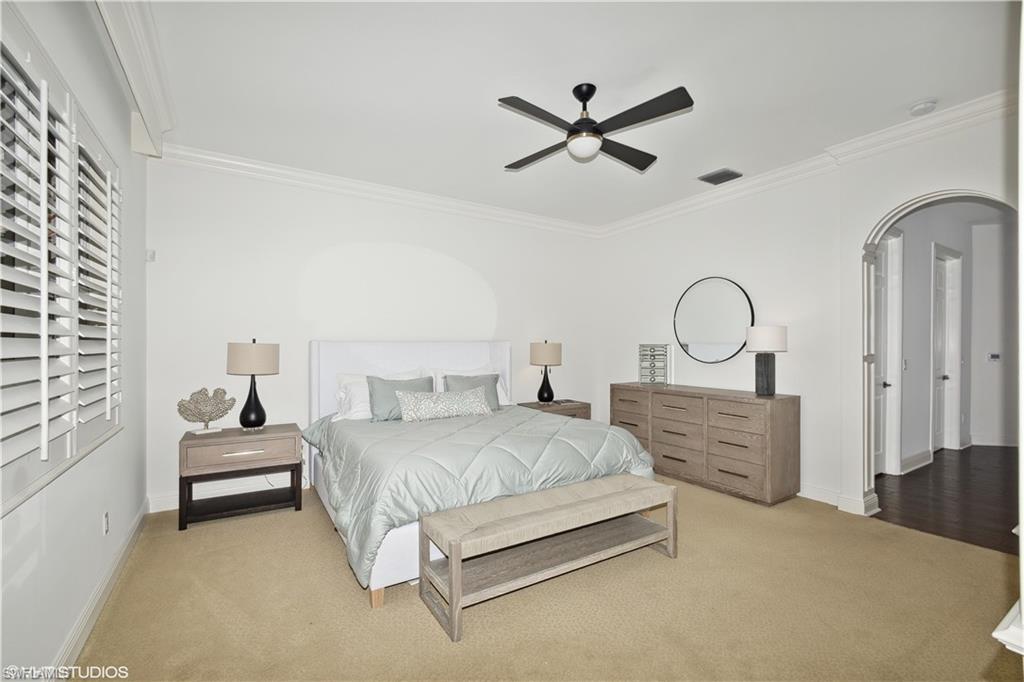 6501 Crown Colony Place, Unit 4201 Naples, FL 34108 - Photo 21 of 35 a bedroom with a bed and chandelier