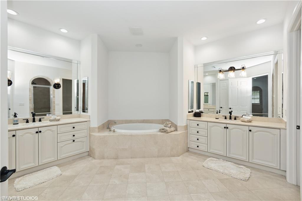 6501 Crown Colony Place, Unit 4201 Naples, FL 34108 - Photo 23 of 35 a spacious bathroom with a double vanity sink mirror and bathtub