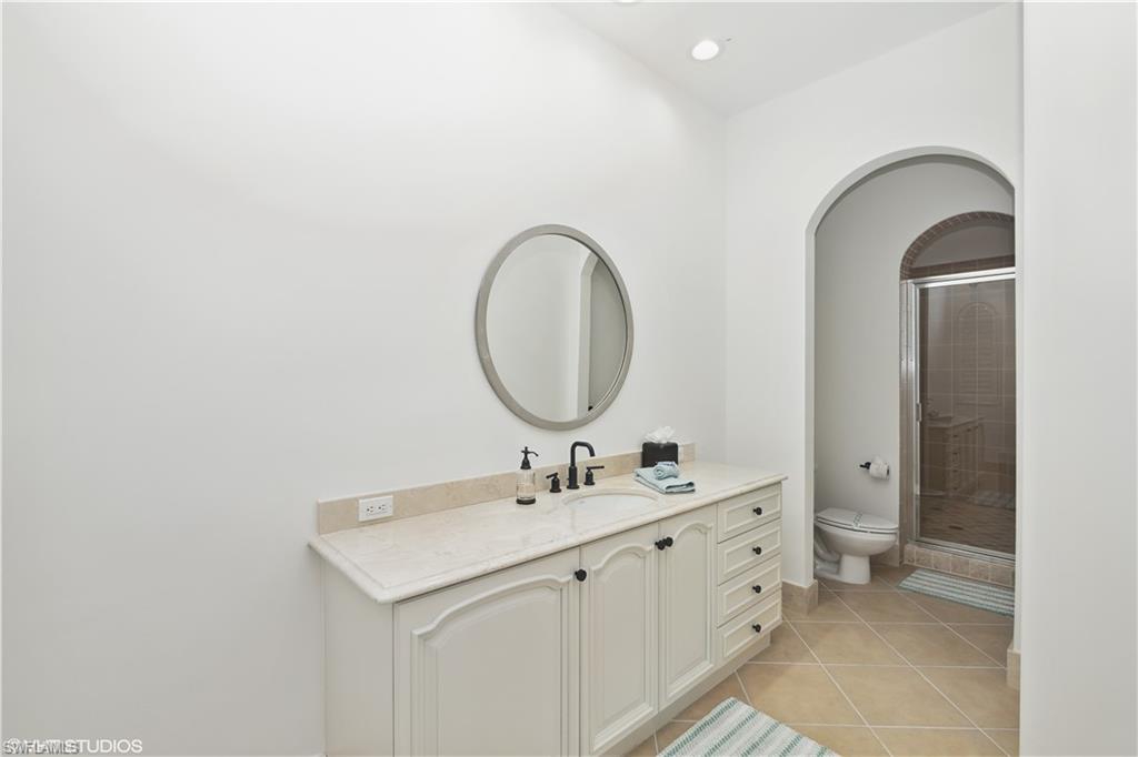 6501 Crown Colony Place, Unit 4201 Naples, FL 34108 - Photo 27 of 35 a bathroom with a double vanity sink and a mirror