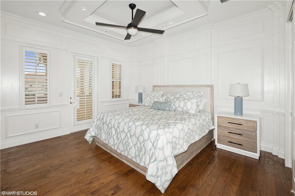 6501 Crown Colony Place, Unit 4201 Naples, FL 34108 - Photo 28 of 35 a bedroom with a bed chandelier and a window