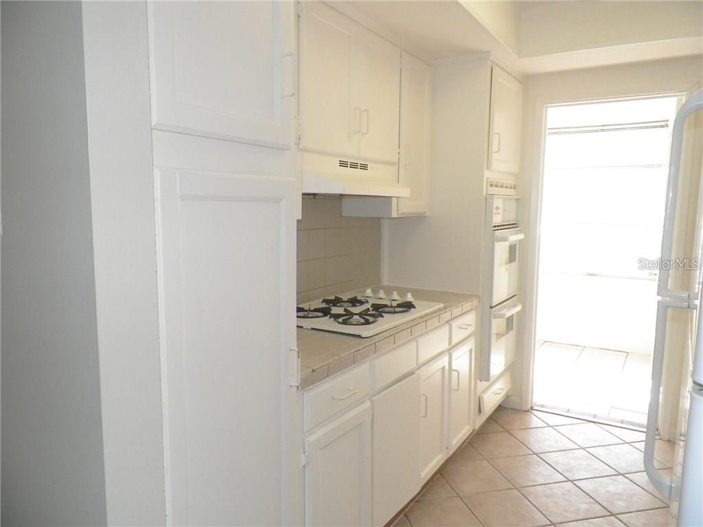911 Washington Avenue Southwest, Unit 304 Largo, FL 33770 - Photo 8 of 26 a kitchen with a stove and a refrigerator