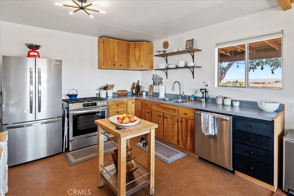 3815 Highway 41 Paso Robles, CA 93446 - Photo 11 of 40 a kitchen with stainless steel appliances a sink a stove a refrigerator cabinets and a dining table