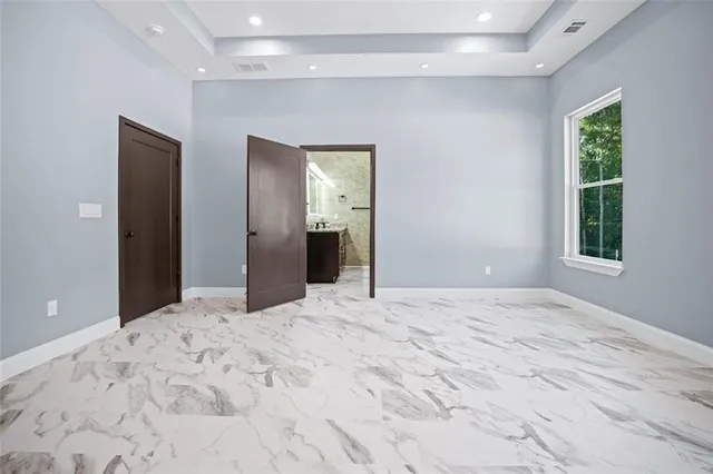 a view of an empty room with window and closet area