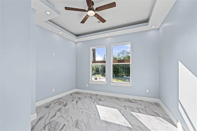 an empty room with a window and a ceiling fan