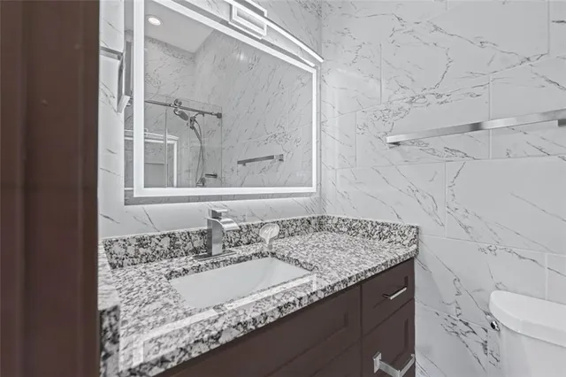 a bathroom with a granite countertop sink and a mirror