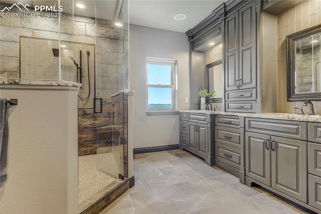 14325 Evans Road Elbert, CO 80106 - Photo 23 of 49 a bathroom with a double vanity sink a toilet and shower
