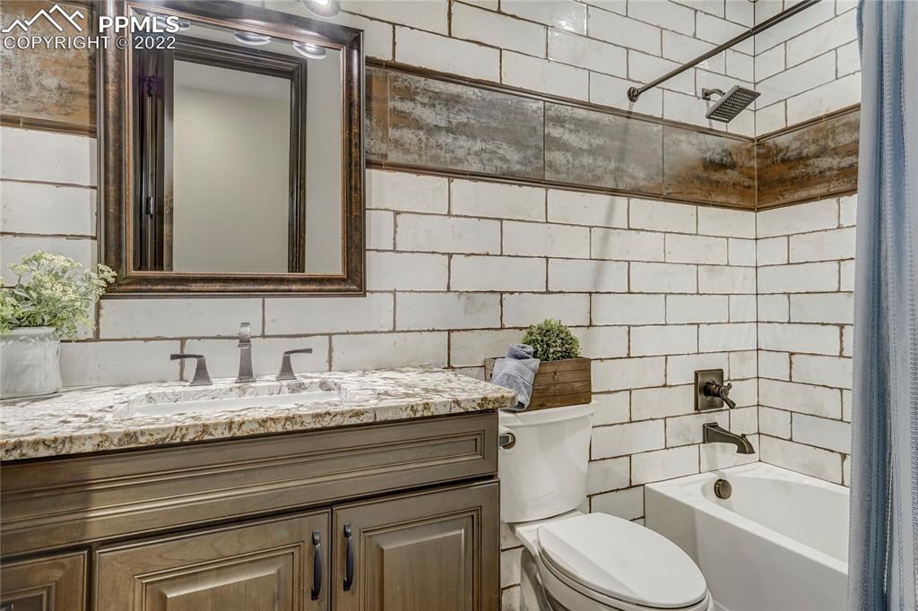 14325 Evans Road Elbert, CO 80106 - Photo 29 of 49 a bathroom with a granite countertop sink and a mirror